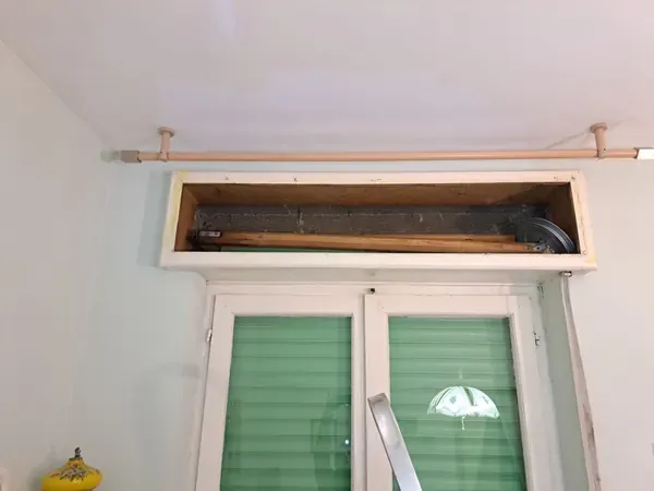 Sostituzione tapparelle a Copparo: cassonetto aperto sopra la finestra per raggiungere rullo e puleggia